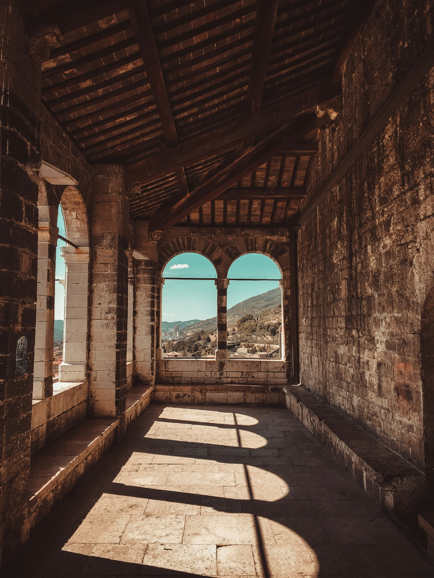 The stone loggia arches framing the hills above Gubbio