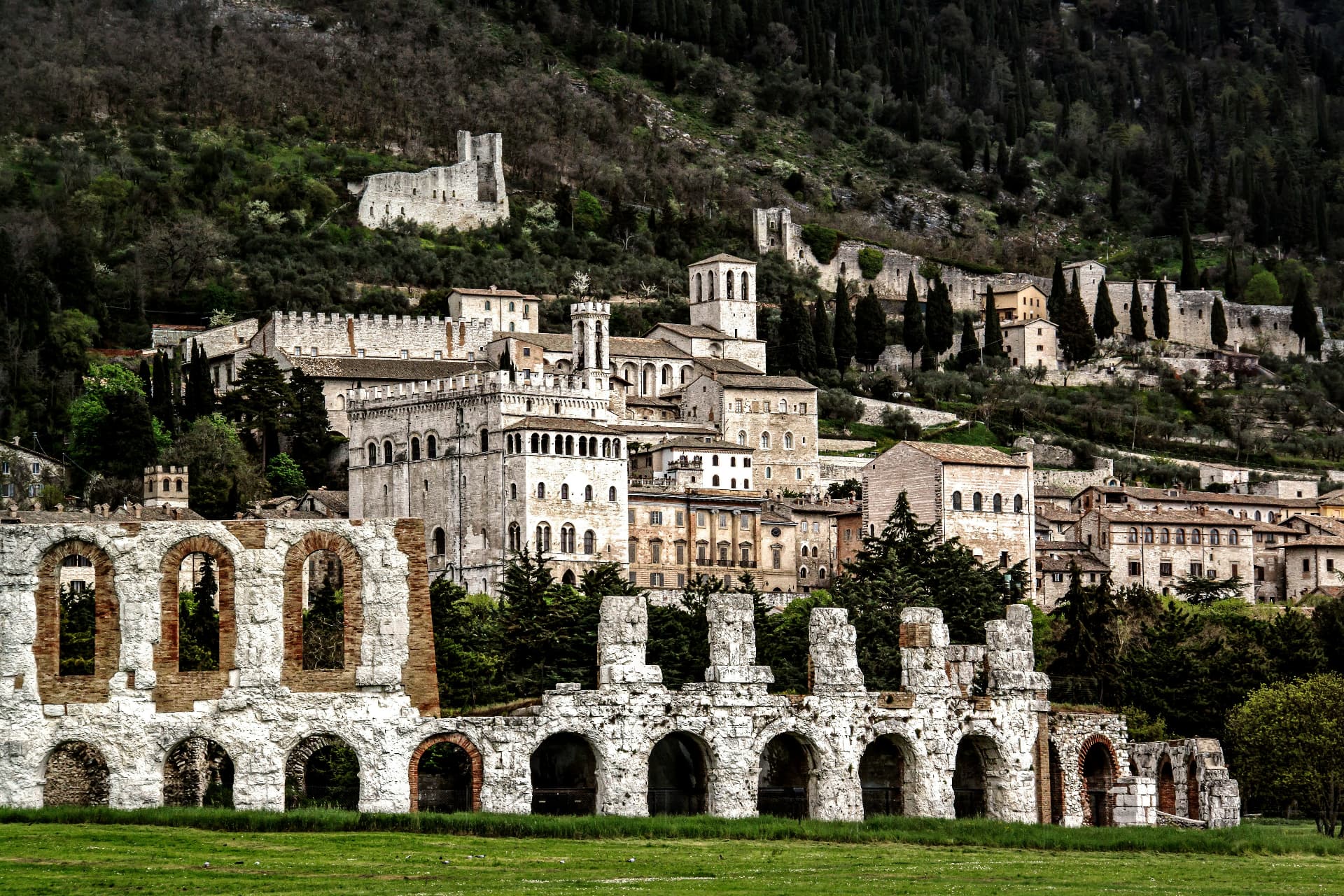 The ruins of the Roman amphitheatre with Gubbio climbing the hillside behind