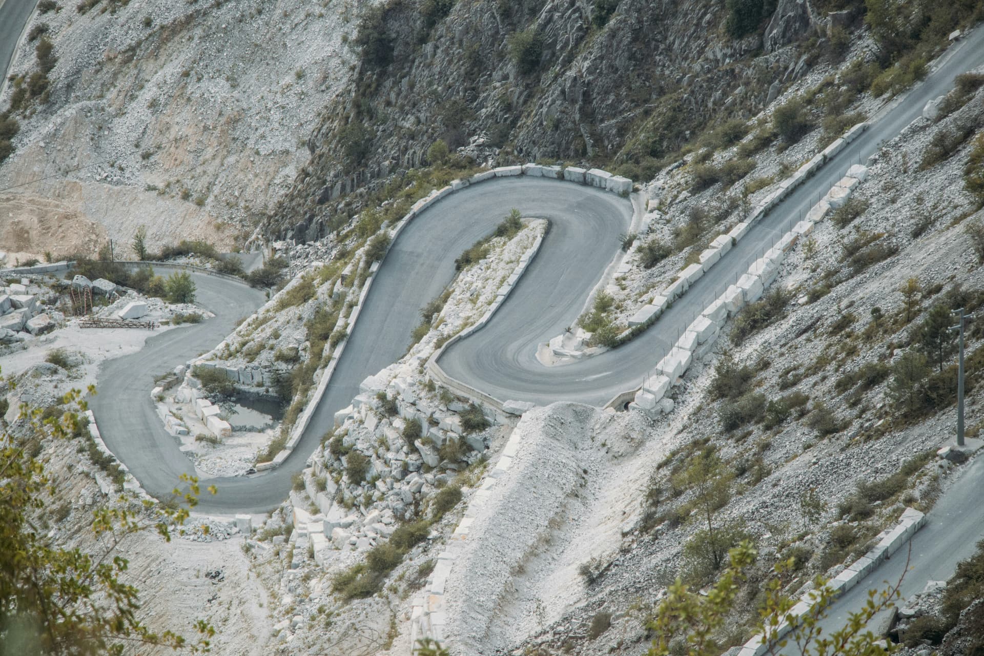 The hairpin road of the marble quarry climbing between walls of white stone