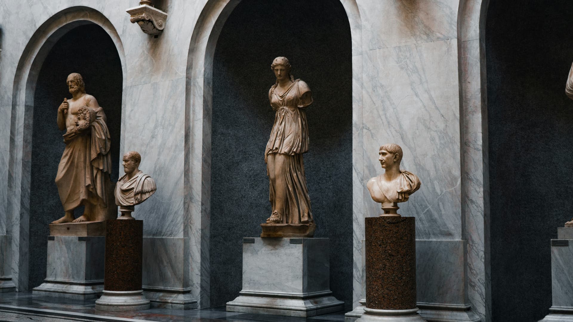 Classical statues standing in arched marble niches