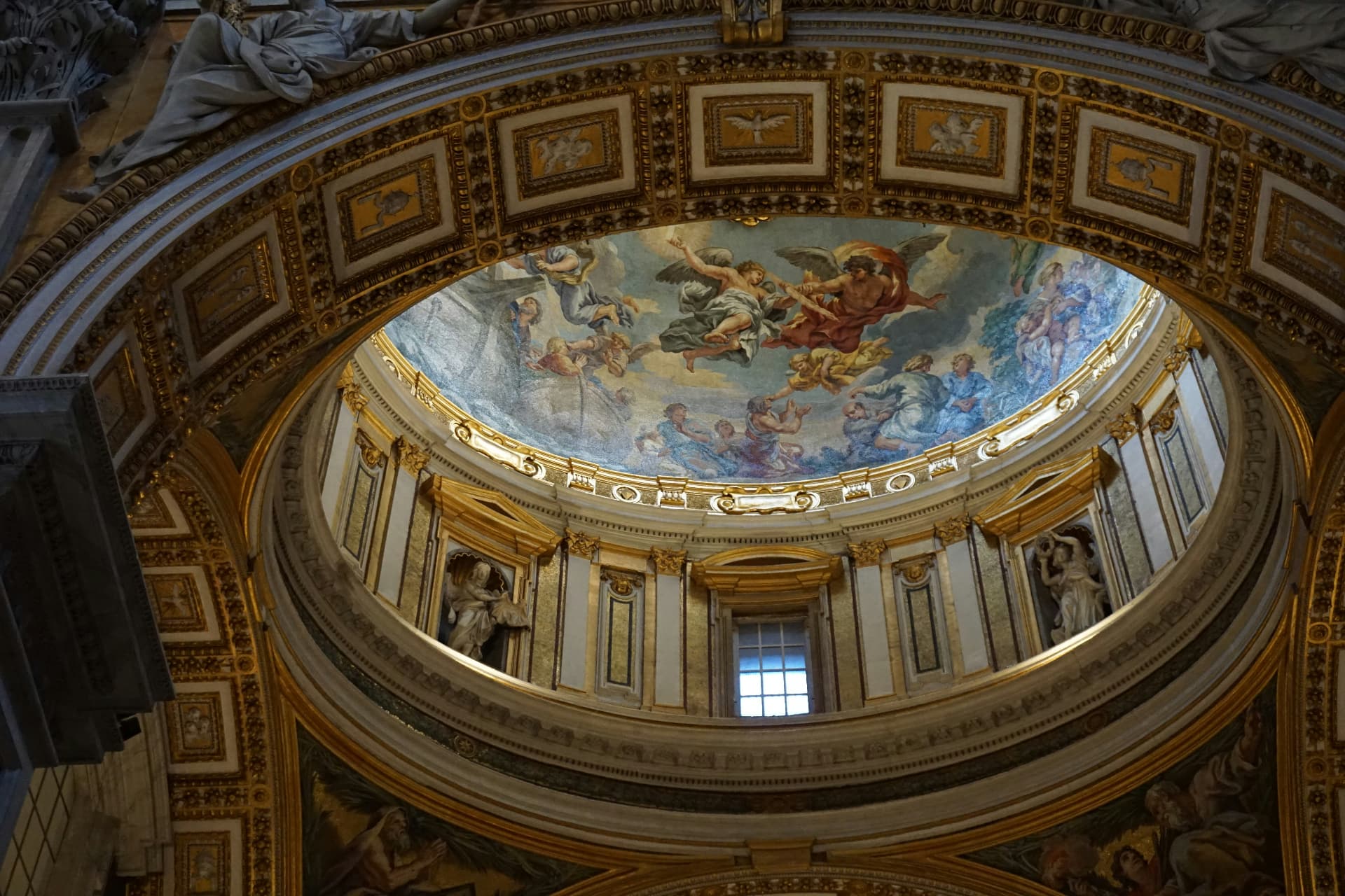 A painted dome of angels and clouds above gilded architecture