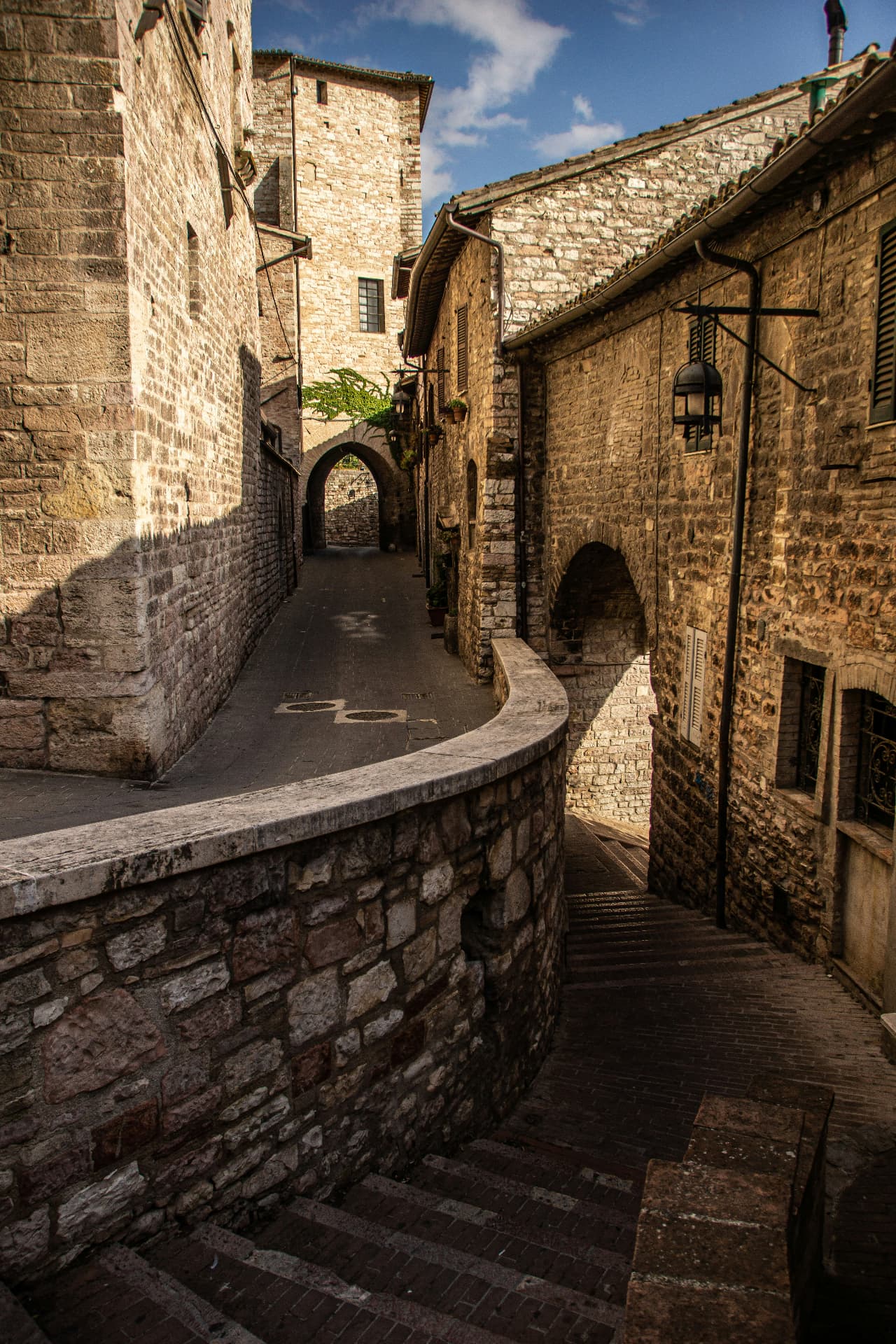 A stone arch and curving lane in Assisi