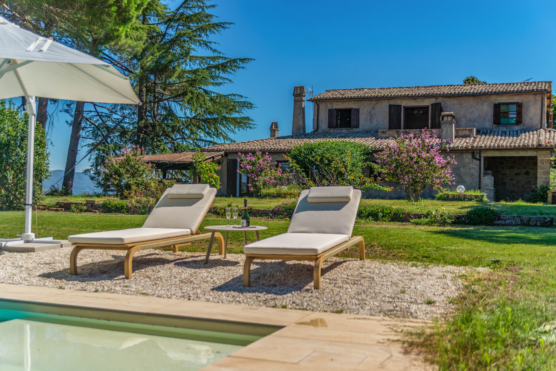 Two sunbeds with champagne by the pool, Il Casone behind