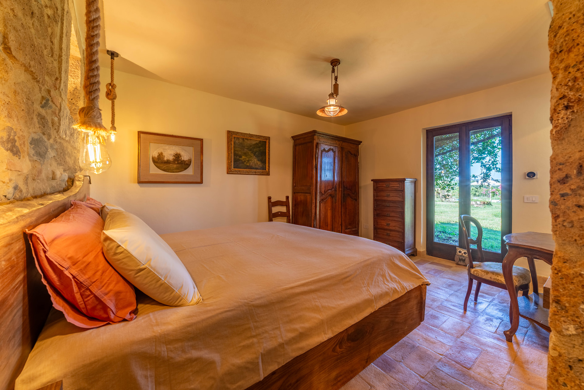 Castagno bedroom with oak trunk headboard, chestnut linen, rope pendant lamp and garden door