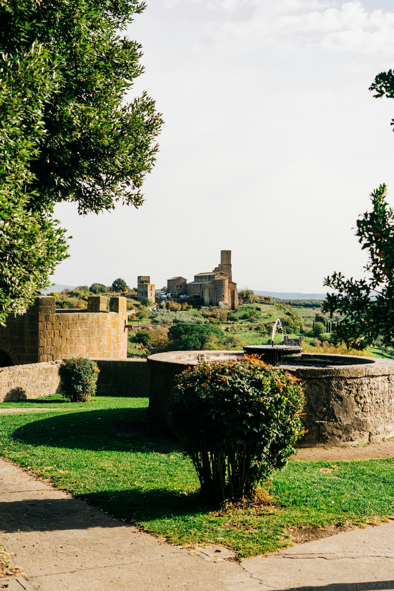 A fountain in the Tuscania garden, San Pietro on the hill beyond