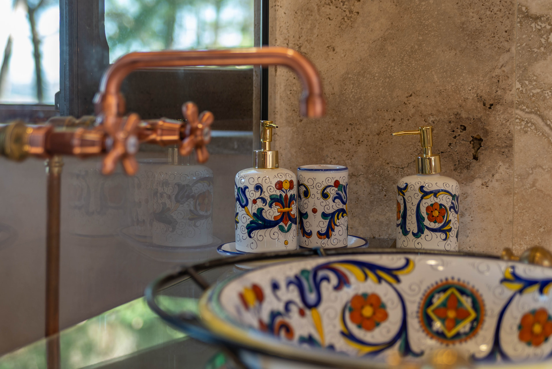 Hand-painted bathroom ceramics and a copper tap