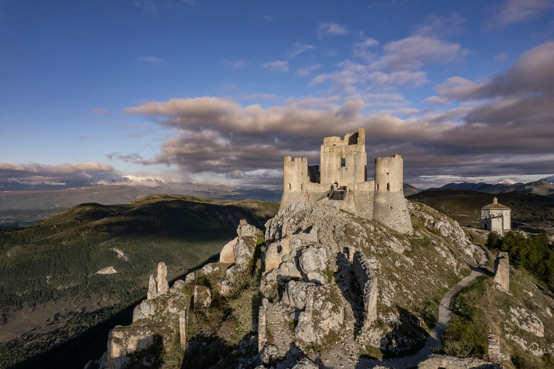 Rocca Calascio on its rocky ridge, the mountain valley beyond
