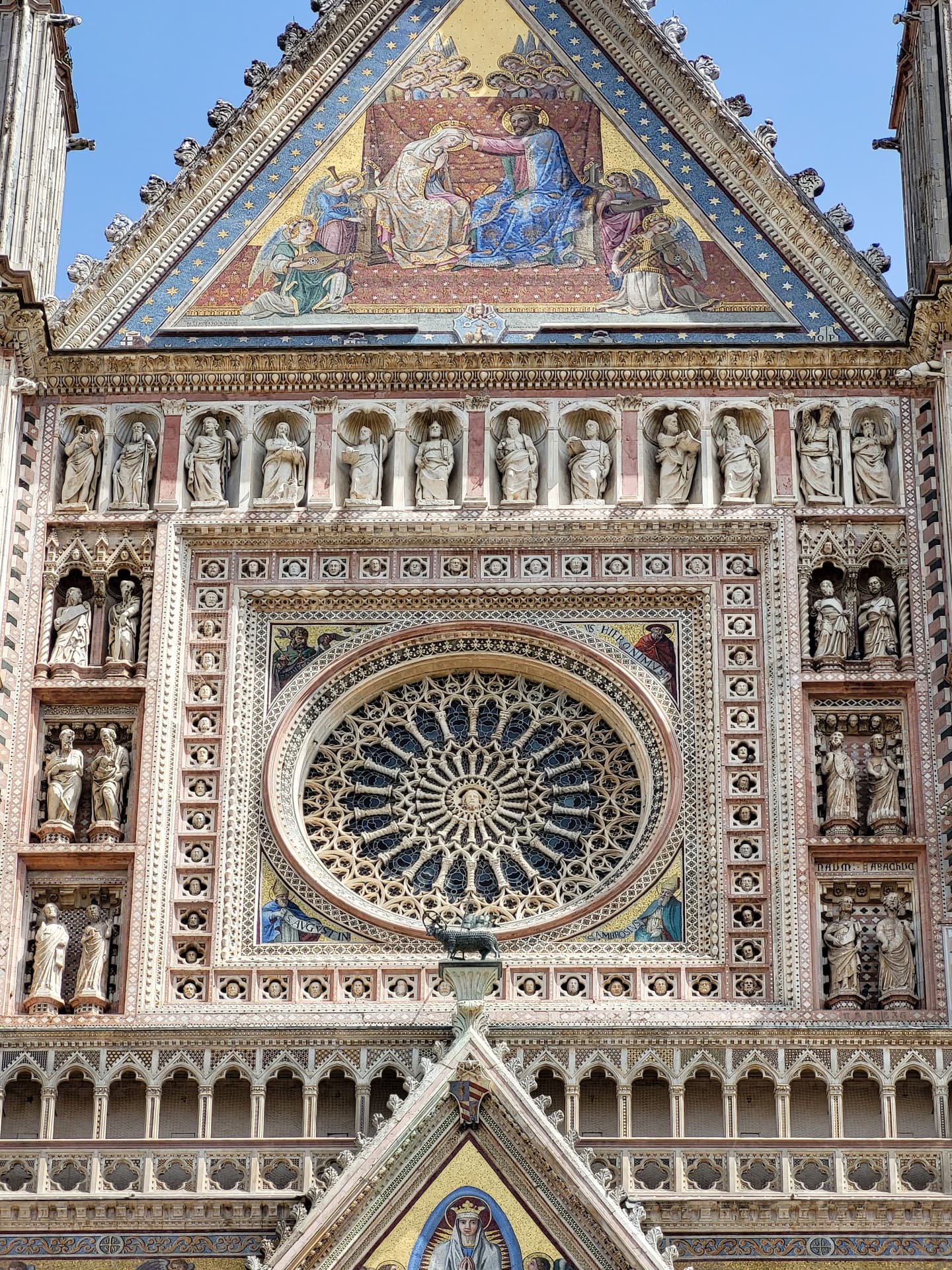 The carved rose window and golden mosaics of Orvieto cathedral in direct sun