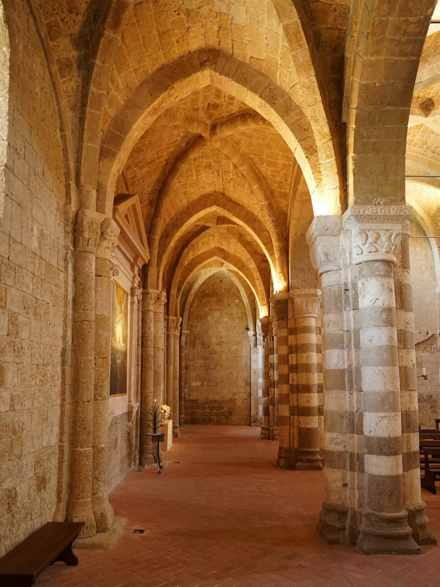 A side aisle of Sovana cathedral, pointed vaults and banded stone columns