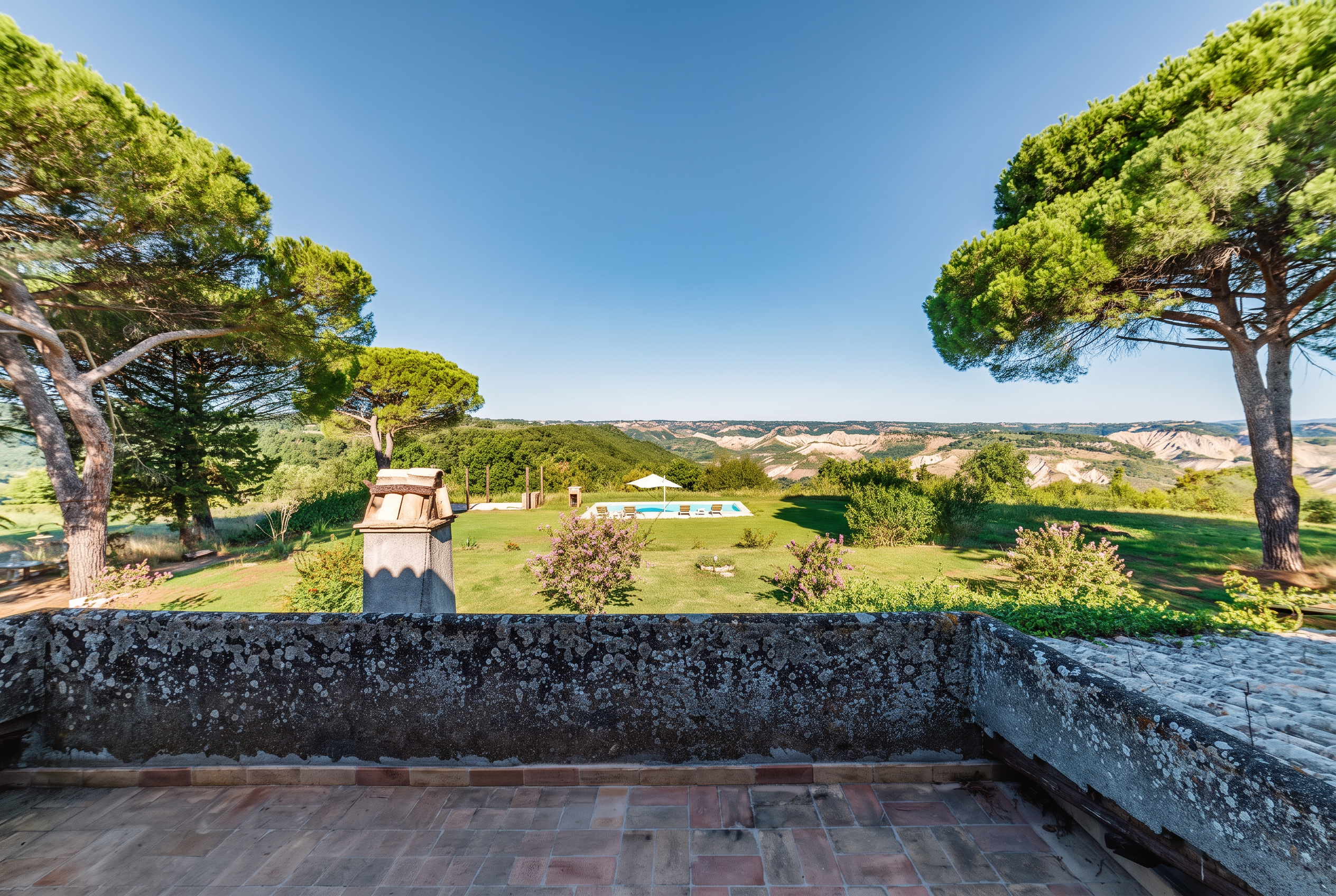The terrace wall, the garden and the pool with the calanchi valley beyond